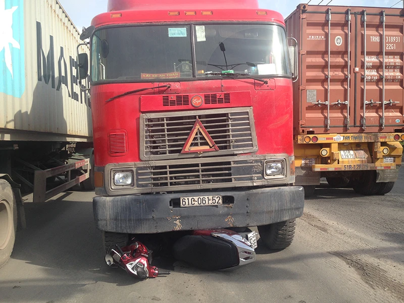 Chiếc xe máy bị cuốn vào gầm xe container, hai mẹ con may mắn thoát nạn 